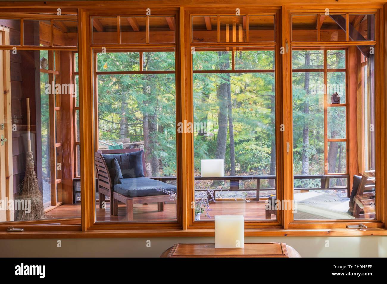 Kleiner indonesischer Teakholztisch plus Blick auf das Home Office durch Fenster im japanischen Esszimmer im offenen Design-Holzrahmen. Stockfoto