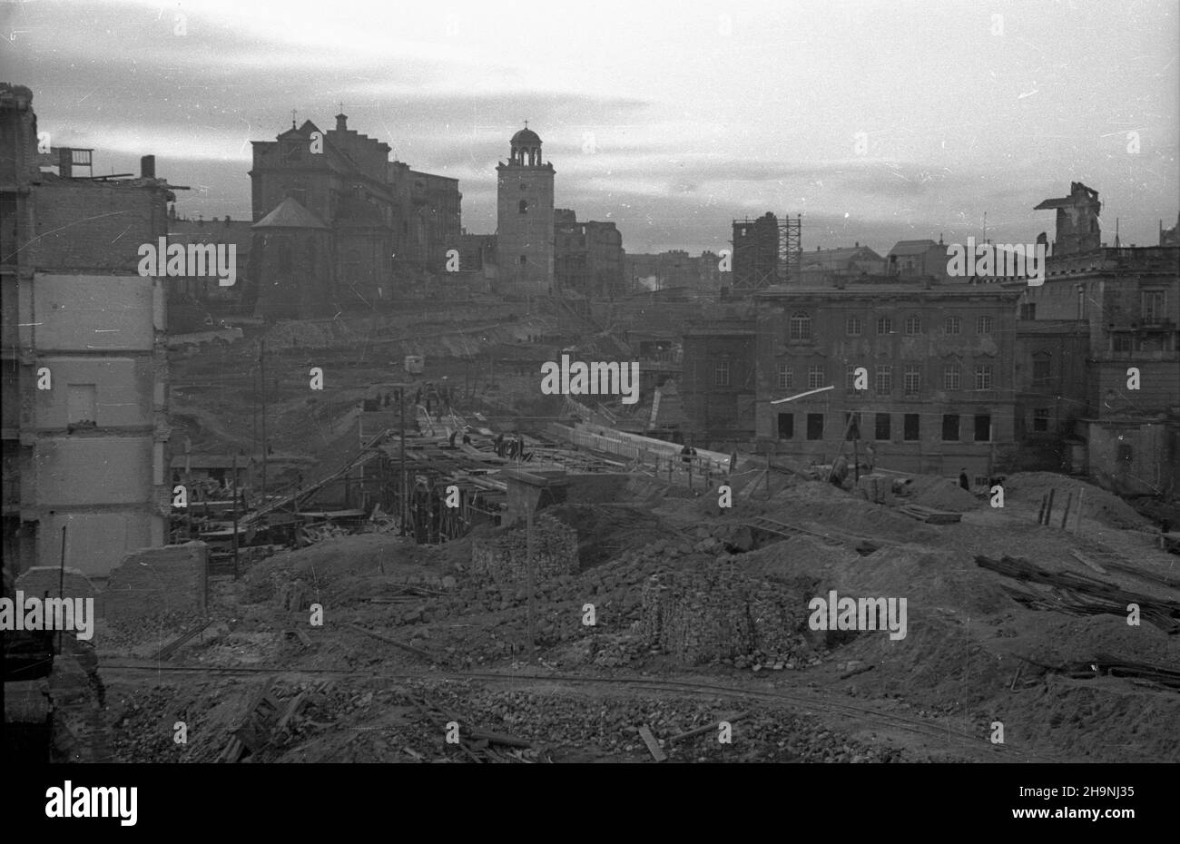 Warszawa, 1948-12. Budowa Trasy W-Z – ci¹gu komunikacyjnego Wschód-Zachód. NZ. prace ziemne i drogowe na wschodnim odcinku (wlot jezdni trasy do tunelu od strony ulicy Krakowskie Przedmieœcie); w g³êbi koœció³ pw. œw. Anny wraz z z dzwonnic¹ (L) i ruiny Zamku Królewskiego (P); z prawej pa³ac Pod Blach¹ - widok z Mariensztatu. mta PAP Dok³adny dzieñ wydarzenia nieustalony. Warschau, 1948. August. Bau der W-Z-Route (Ost-West-Kommunikationsleitung). Im Bild: Straßenarbeiten im östlichen Teil (Tunneleingang von der Krakowskie Przedmiescie Street). Im Hintergrund die St. Anna Kirche mit ihren Stockfoto