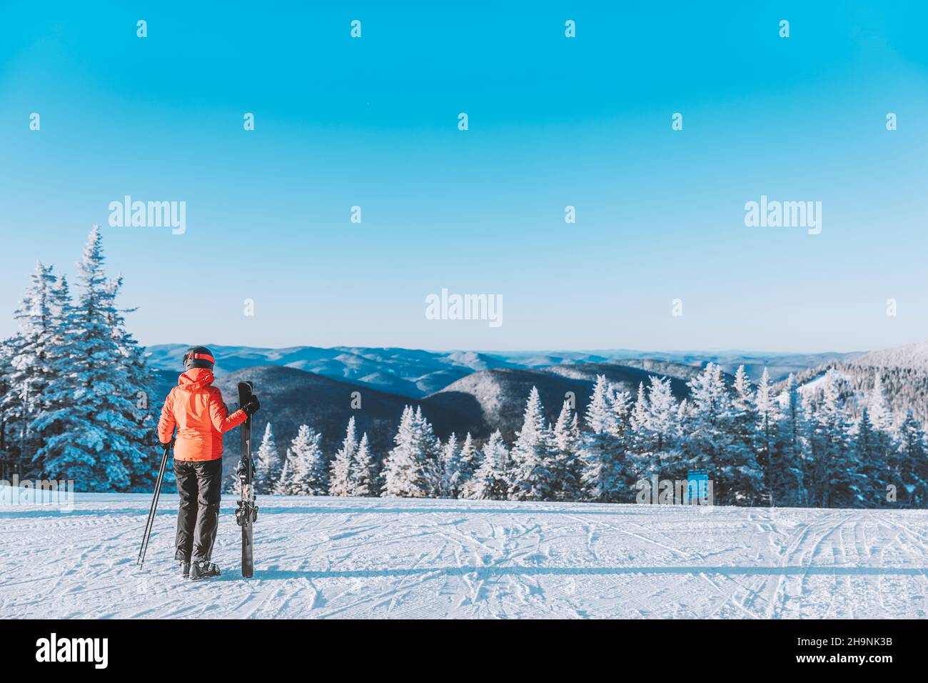 Winterurlaub Skiurlaub. Frau Skifahrer Blick auf die Berglandschaft Natur im Freien stehend Skier halten. Alpine Ski fahren weißen Pulverschnee Stockfoto