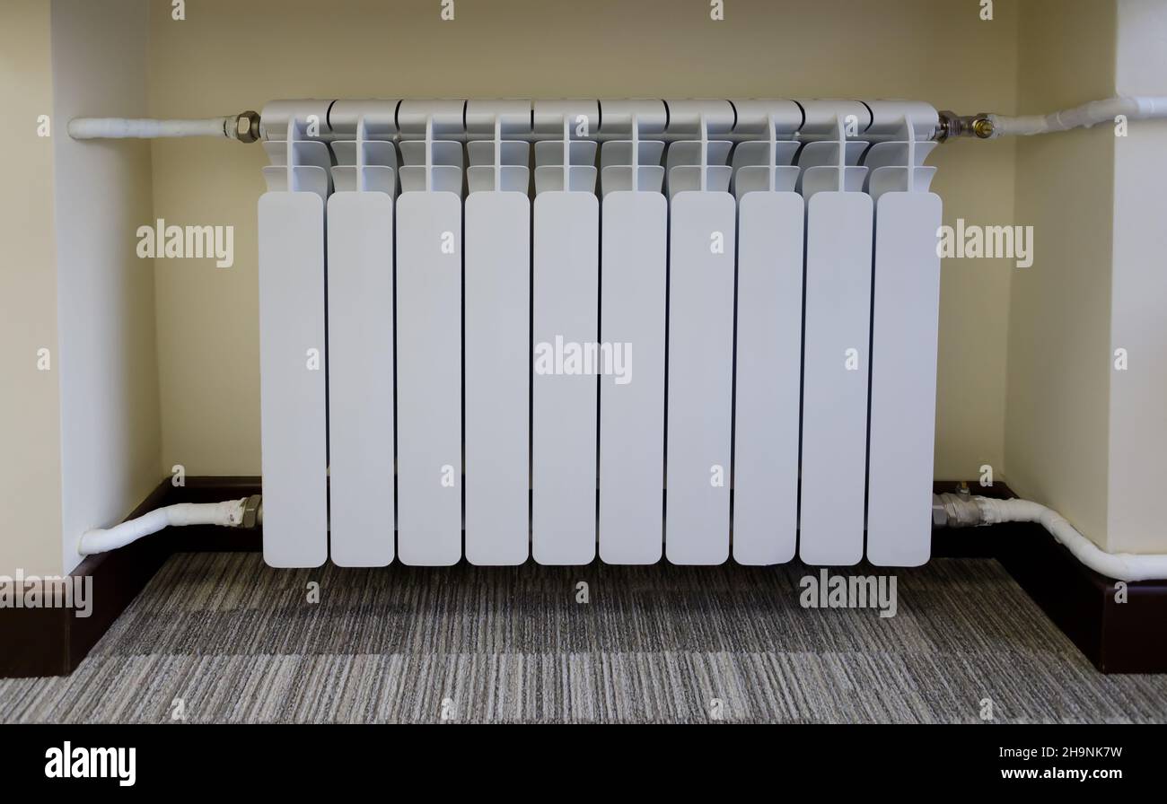 Moderne Heizbatterien. Weißer, warmer Kühler. Konzept der Notwendigkeit einer guten Zentralheizung. Stockfoto