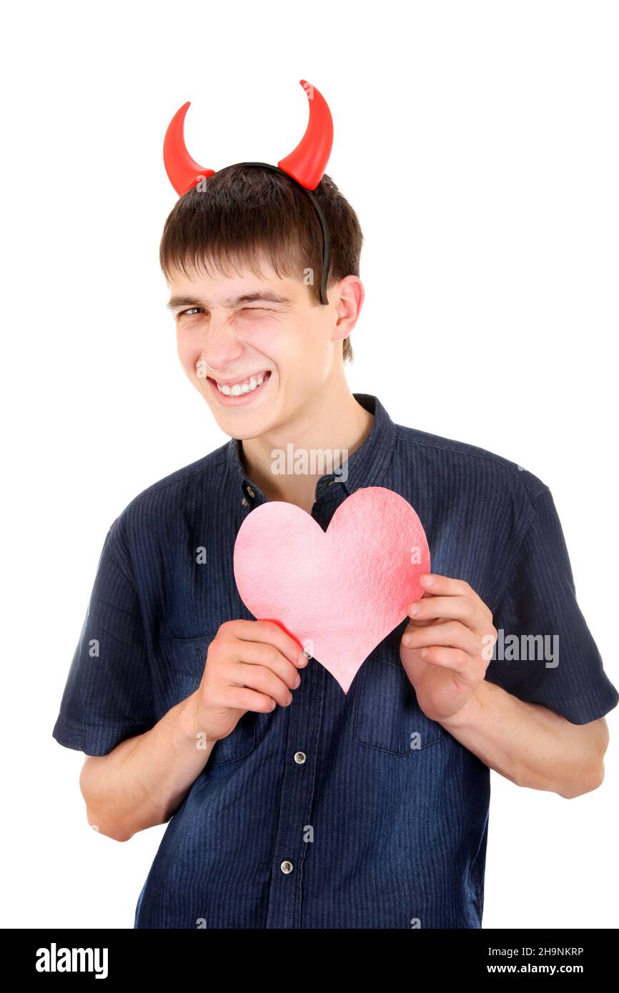 Schlauer Teenager mit Teufelshörnern und roter Herzform isoliert auf dem weißen Hintergrund Stockfoto