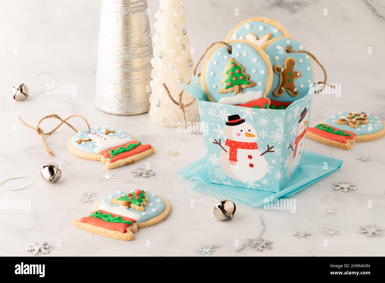 Eine Geschenkbox mit hausgemachten Schneekugel-Keksen mit mehr Keksen rund um den Globus. Stockfoto