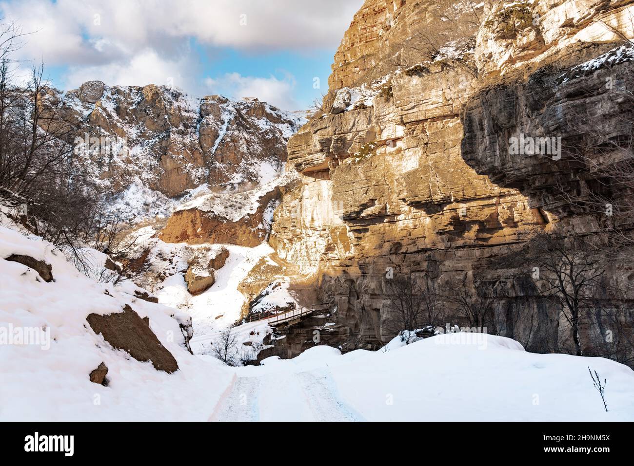 Enge verschneite Straße in einer Bergschlucht Stockfoto