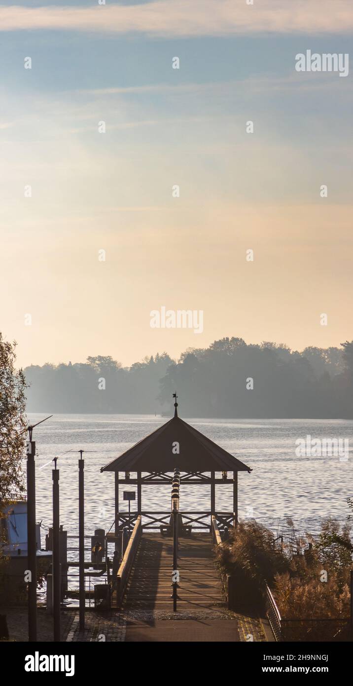 Panoramablick auf eine hölzerne Anlegestelle unter dem Sonnenuntergang im Stadtteil Ostprignitz-Ruppin, Deutschland Stockfoto