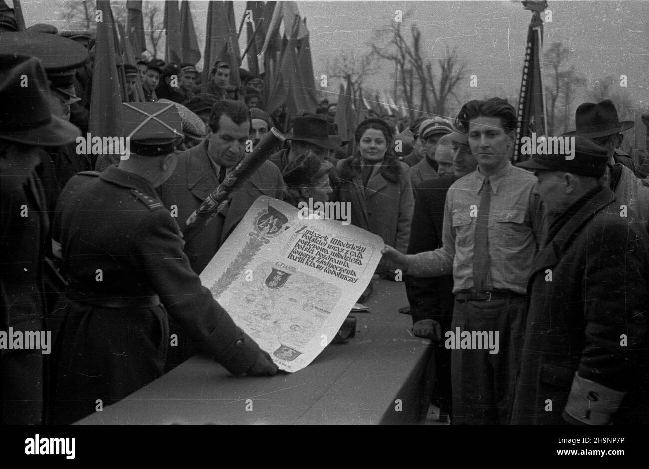 Warszawa, 1948-12-15. Plac Zwyciêstwa. DLA uczczenia i Zjazdu Polskiej Zjednoczonej Partii Robotniczej (PZPR) z 8 miast Polski (Gdañska, Olsztyna, Bia³egostoku, Lublina, Rzeszowa, Katowic, Wroc³awia i Szczecina) przybieg³y do Warszawy sztafety m³odzie¿y. NZ. reprezentuj¹cy sztafetê z Gdañska Mieczys³aw Stanke sk³ada na rêce sekretarza Komitetu Centralnego Zwi¹zków Zawodowych Boles³awa Geberta (2L) meldunek o zakoñczeniu biegu. W g³êbi cz³onkini Zwi¹zku M³odzie¿y Polskiej z Katowic Sabina Ma³otówna. ka PAP Warschau, 15. Dezember 1948. Zu Ehren des Kongresses der Polnischen Vereinigten Arbeiterpartei von 1st Stockfoto