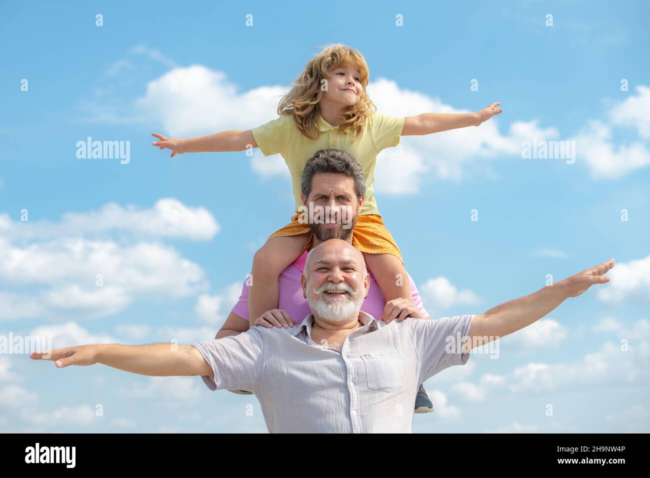 Generationenfamil. Vater, Sohn und Großvater glücklich Multi-Genration Familie mit Heben der Hände oder offene Arme fliegen am Himmel. Stockfoto