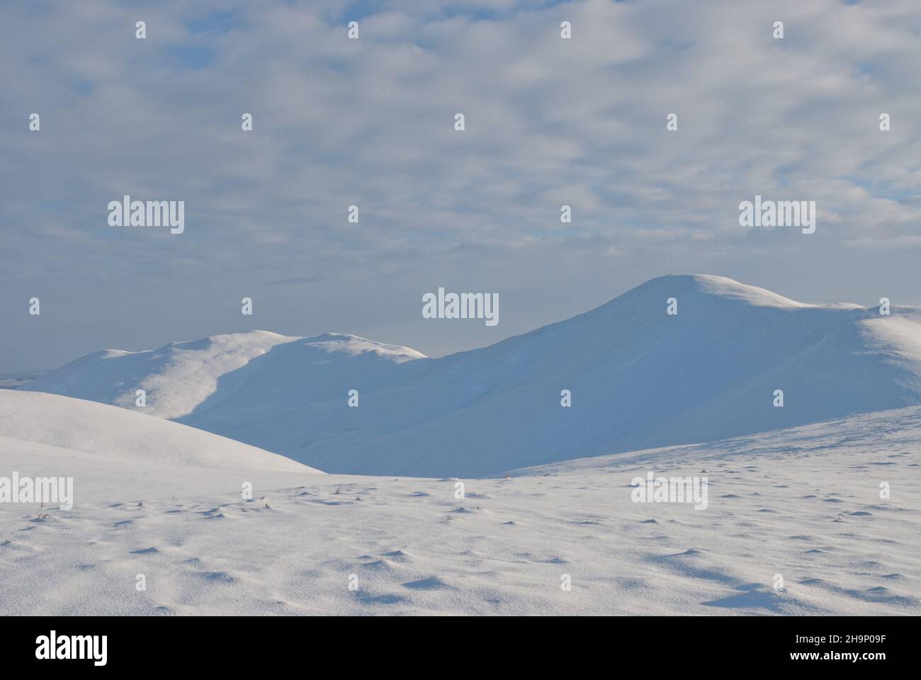 Winterliche Szene aus den Pentland-Hügeln während des verschneiten Winters 2009/2010, in der Wanderer einen verschneiten Bergrücken durchqueren. Stockfoto