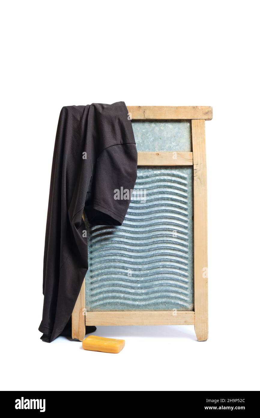 Waschbrett mit einem Stück Seife und schmutzigem Hemd auf weißem Hintergrund Stockfoto