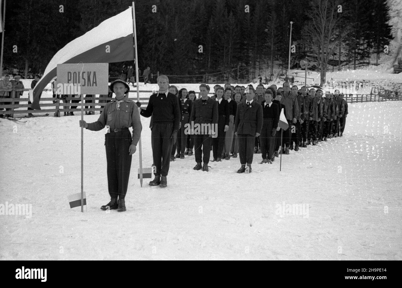 Zakopane, 1949-02-23. OD 23 lutego do 3 marca odbywa³y siê Miêdzynarodowe Zawody Narciarskie o Puchar Tatr. Zgromadzi³y one kilkudziesiêciu sportowców z Polski, Bu³garii, Czechos³owacji, Finlandii, Rumunii i Wêgier. Pierwszego dnia, na stadionie Pod Krokwi¹, odby³o siê uroczyste otwarcie zawodów. NZ. Ekipa sportowców z Polski. Flagê trzyma Stefan Dziedzic. pw PAP Zakopane, 23. Februar 1949. Vom 23. Februar bis 3. März fand der internationale Skiwettbewerb für den Pokal der Tatra statt. An diesem Wettbewerb nahmen mehrere Dutzend Sportler aus Polen, Bulgarien, der Tschechoslowakei und Finnland Teil Stockfoto