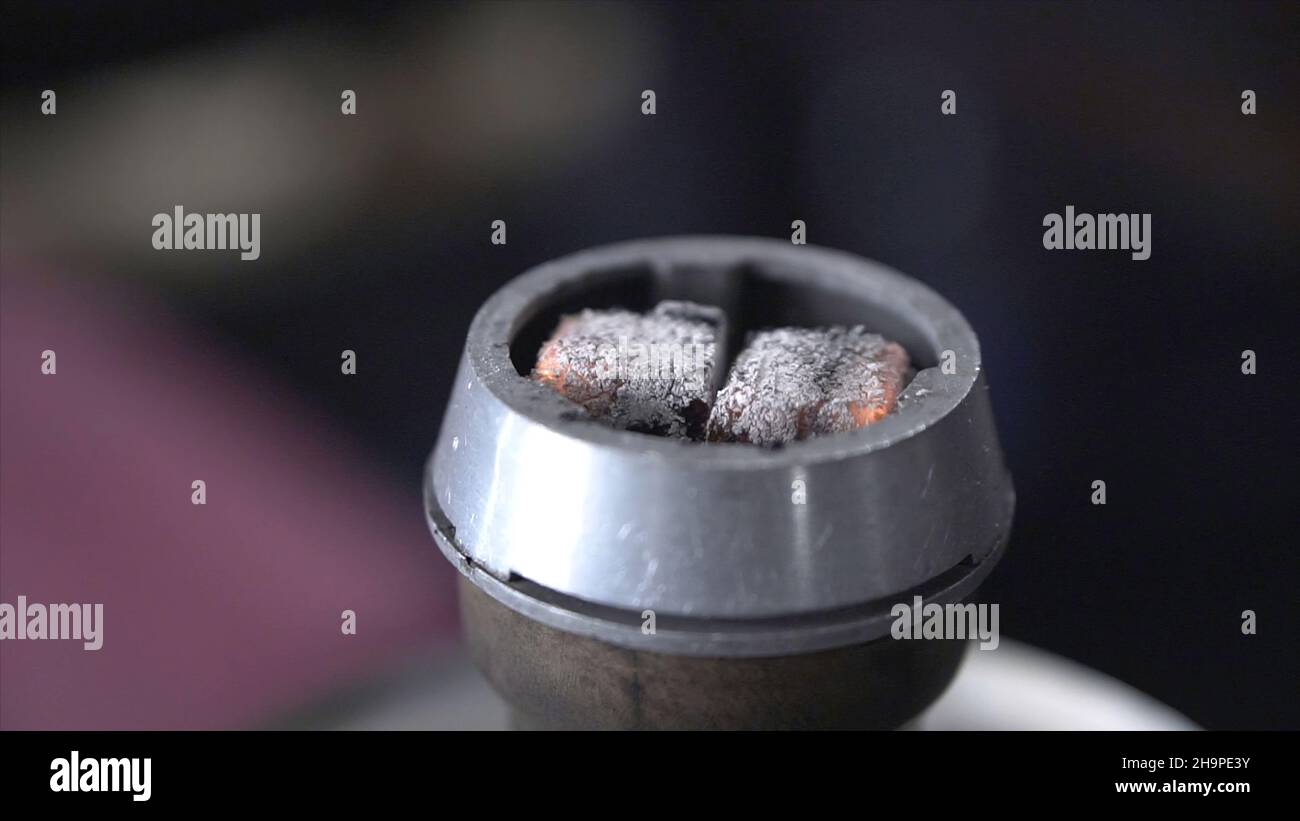 Shisha-Shisha mit roten heißen Kohlen.Clip. Moderne Shisha mit Kokoskohle für Entspannung und Shisha-Rauch. Stockfoto