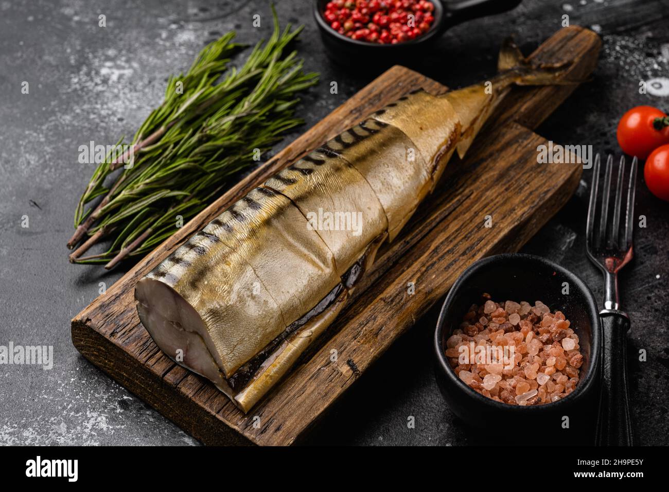 Set mit kalten geräucherten Makrelen-Fischen, auf schwarzem dunklen Steinteller-Hintergrund Stockfoto