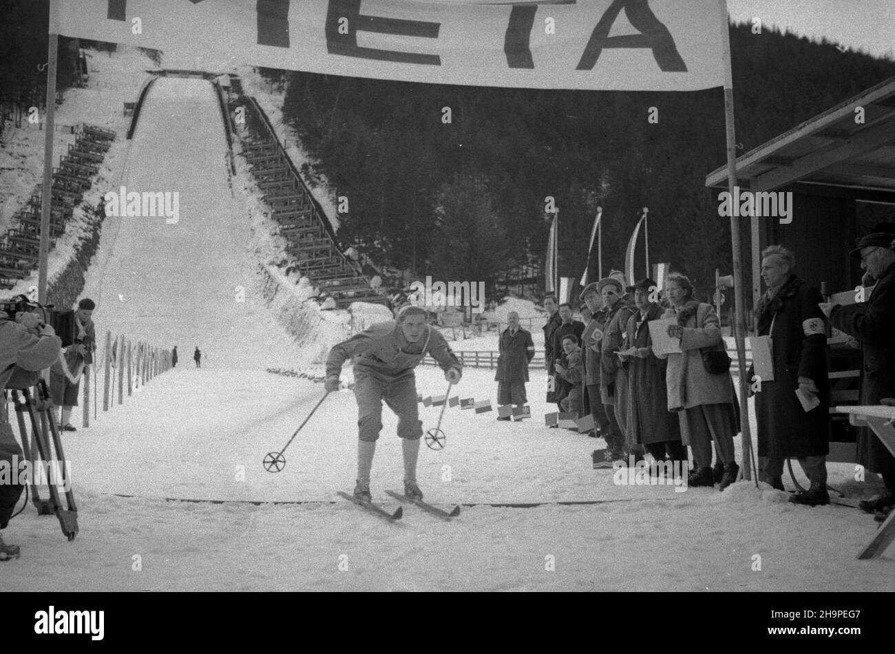 Zakopane, 1949-02-24. OD 23 lutego do 3 marca odbywa³y siê Miêdzynarodowe Zawody Narciarskie o Puchar Tatr. Zgromadzi³y one kilkudziesiêciu sportowców z Polski, Bu³garii, Czechos³owacji, Finlandii, Rumunii i Wêgier. Pierwszego dnia zawodów odby³ siê bieg kobiet na 8 kilometrów. Trasa prowadzi³a od górnej stacji kolejki na Guba³ówce do stadionu Pod Krokwi¹. NZ. na mecie zwyciê¿czyni biegu Maire Saloranta z Finlandii. pw PAP Zakopane, 24. Februar 1949. Vom 23. Februar bis 3. März fand der internationale Skiwettbewerb für den Pokal der Tatra statt. Der Wettbewerb brachte seve zusammen Stockfoto