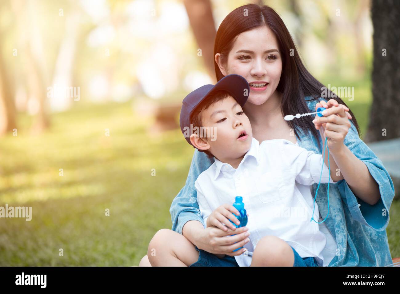 Asiatisch jung teen schön Mutter spielend mit sie Kind im Park draußen Stockfoto