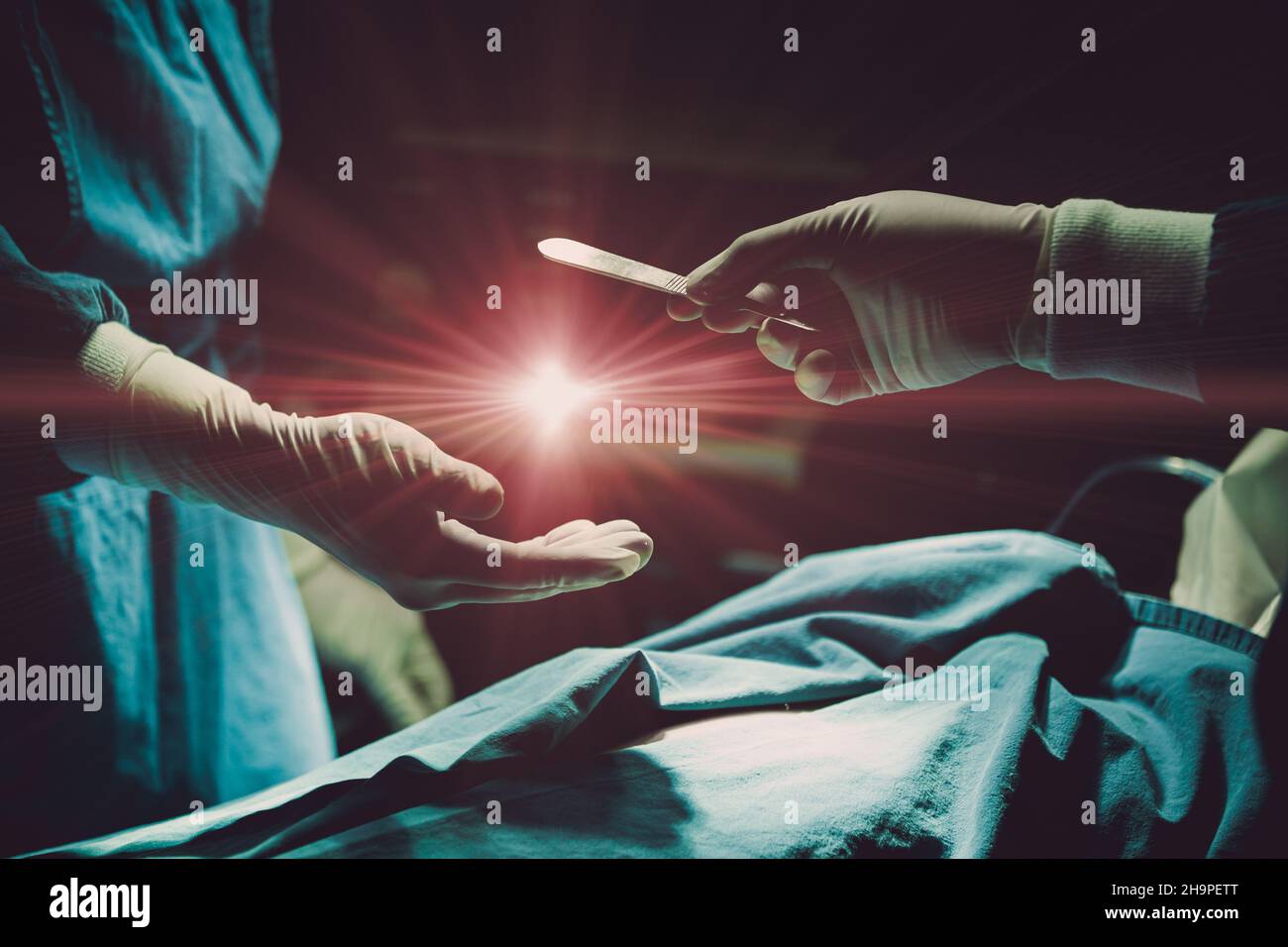 Arzt, der einen Patienten im Krankenhaus operiert, der eine OP-Klinge mit leichtem Aufflackern sendet, um das Konzept des Organspenders zu nutzen. Stockfoto