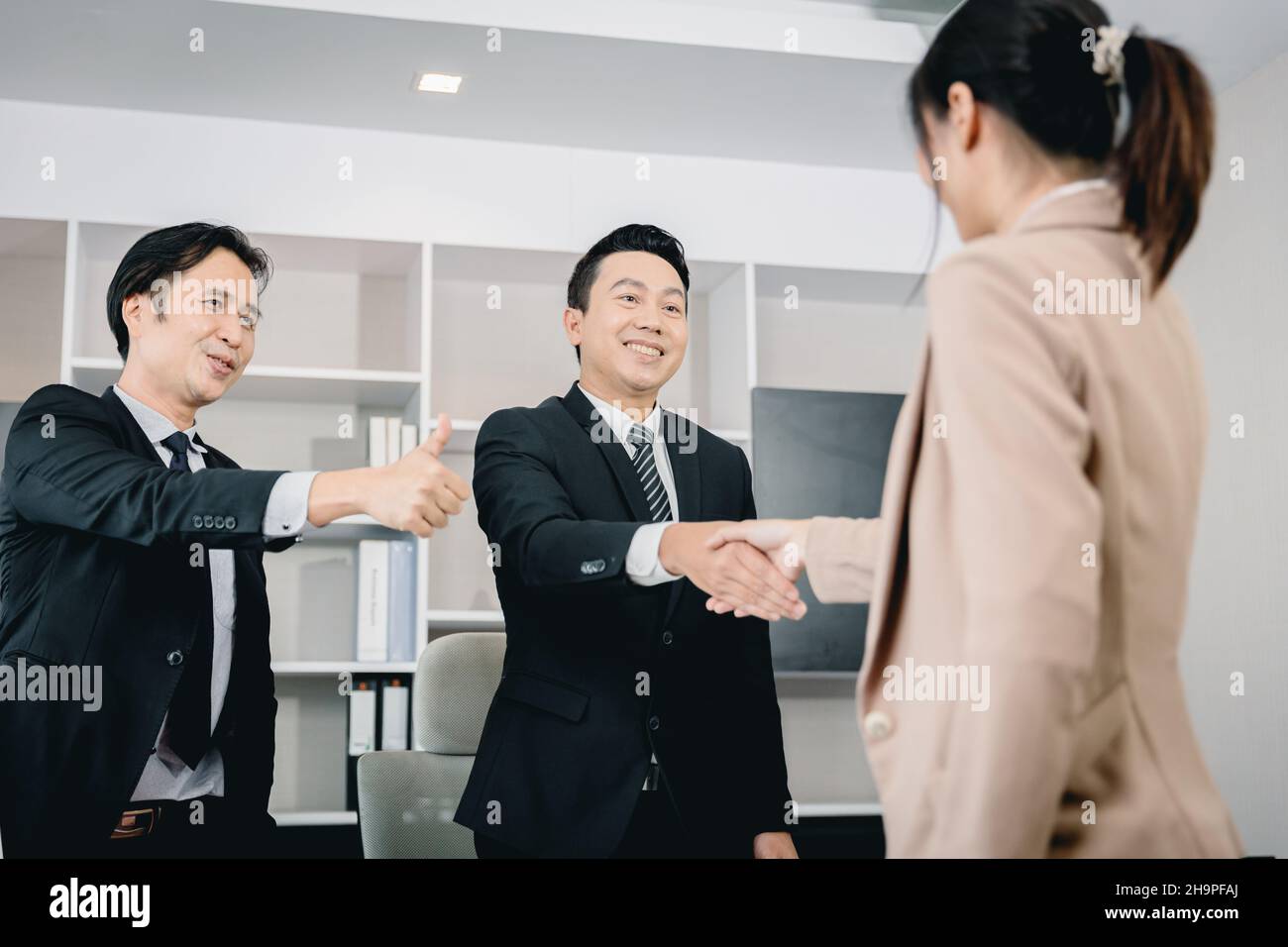 Mitarbeiter des Geschäftsbüros fördern das Händeschütteln mit dem Chef-Teamleiter. Stockfoto