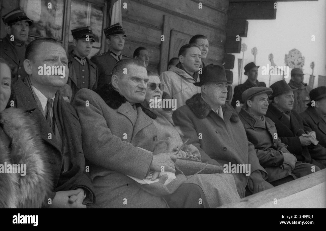 Zakopane, 1949-02-25. W Miêdzynarodowych Zawodach Narciarskich o Puchar Tatr wziê³o udzia³ przesz³o 250 zawodników i zawodniczek reprezentuj¹cych szeœæ pañstw: Czechos³owacjê, Wêgry, Rumuniê, Bu³gariê, Finlandiê i Polskê. Otwarty konkurs skoków obejrza³o na stadionie PZN (Polski Zwi¹zek Narciarski) pod Krokwi¹ dwadzieœcia tysiêcy widzów. Konkurs skoków z lo¿y honorowej obserwowali przedstawiciele najwy¿szych w³adz Polski. NZ. siedz¹ m.in.: dyrektor Departamentu Teatru Ministerstwa Kultury i Sztuki, Literat Stanis³aw Ryszard Dobrowolski (L), Minister pracy i opieki spo³ecznej Kazimierz Rusinek Stockfoto