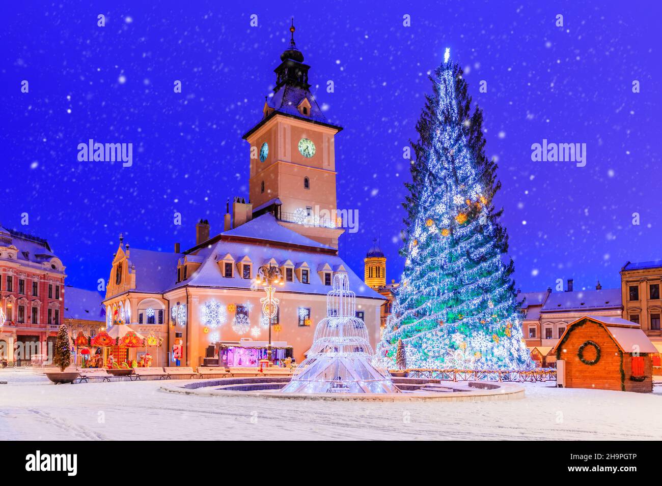 Brasov, Rumänien. Altstädter Weihnachtsmarkt bei Dämmerung mit Schneeeffekt. Stockfoto