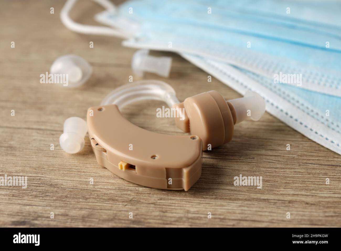 Konzept der Gesundheitsfürsorge mit Hörgerät auf Holzhintergrund Stockfoto