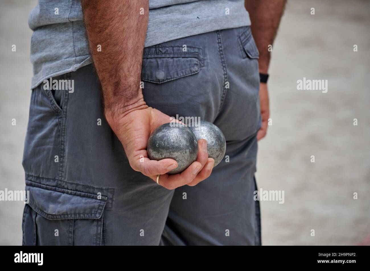 Petanque: Nahaufnahme von Bällen in den Händen eines Mannes, hinter seinem Rücken Stockfoto