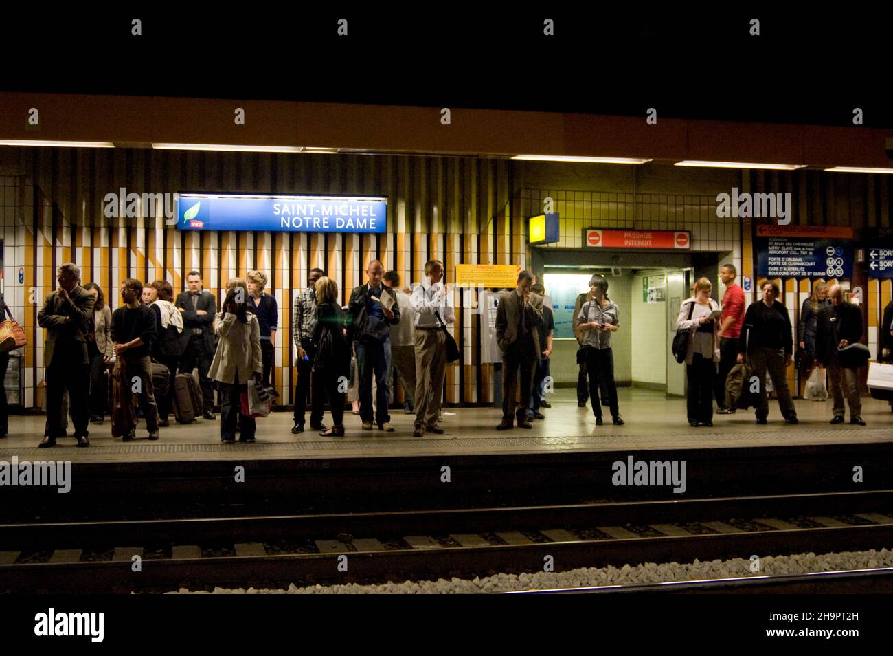 Passagiere, die auf einem U-Bahnsteig im Bahnhof Saint Michel Notre Dame in Paris in Frankreich warten Stockfoto