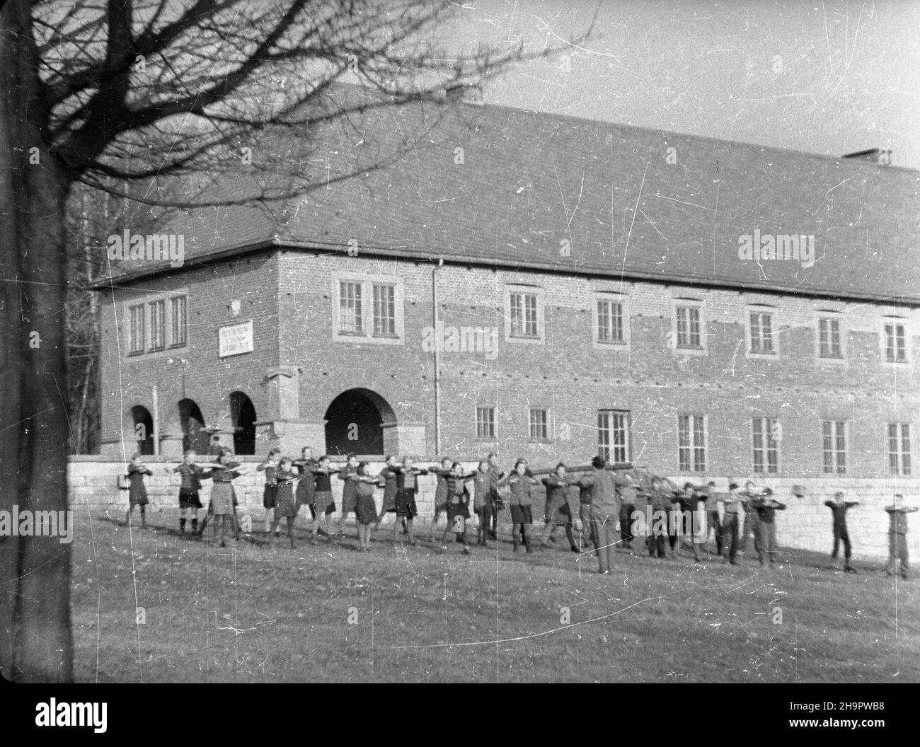 Kudowa Zdrój, 1949-03-07. W dniach 7-14 marca obchodzony jest Tydzieñ PrzyjaŸni Polsko-Czechos³owackiej. W Publicznej Szkole Powszechnej z czeskim jêzykiem nauczania dzieci maj¹ od dziœ specjalne zajêcia na ten temat. NZ. Lekcja gimnastyki przed budynkiem szko³y. mw PAP Kudowa Zdroj, 7. März 1949. Die Woche der Polnisch-Tschechoslowakischen Freundschaft fand am 7. Und 14. März statt. Spezielle Kurse zu diesem Thema werden in einem örtlichen Gymnasium mit Tschechisch als Lehrsprache abgehalten. Im Bild: Ein Gymnastikkurs vor der Schule. mw PAP Stockfoto