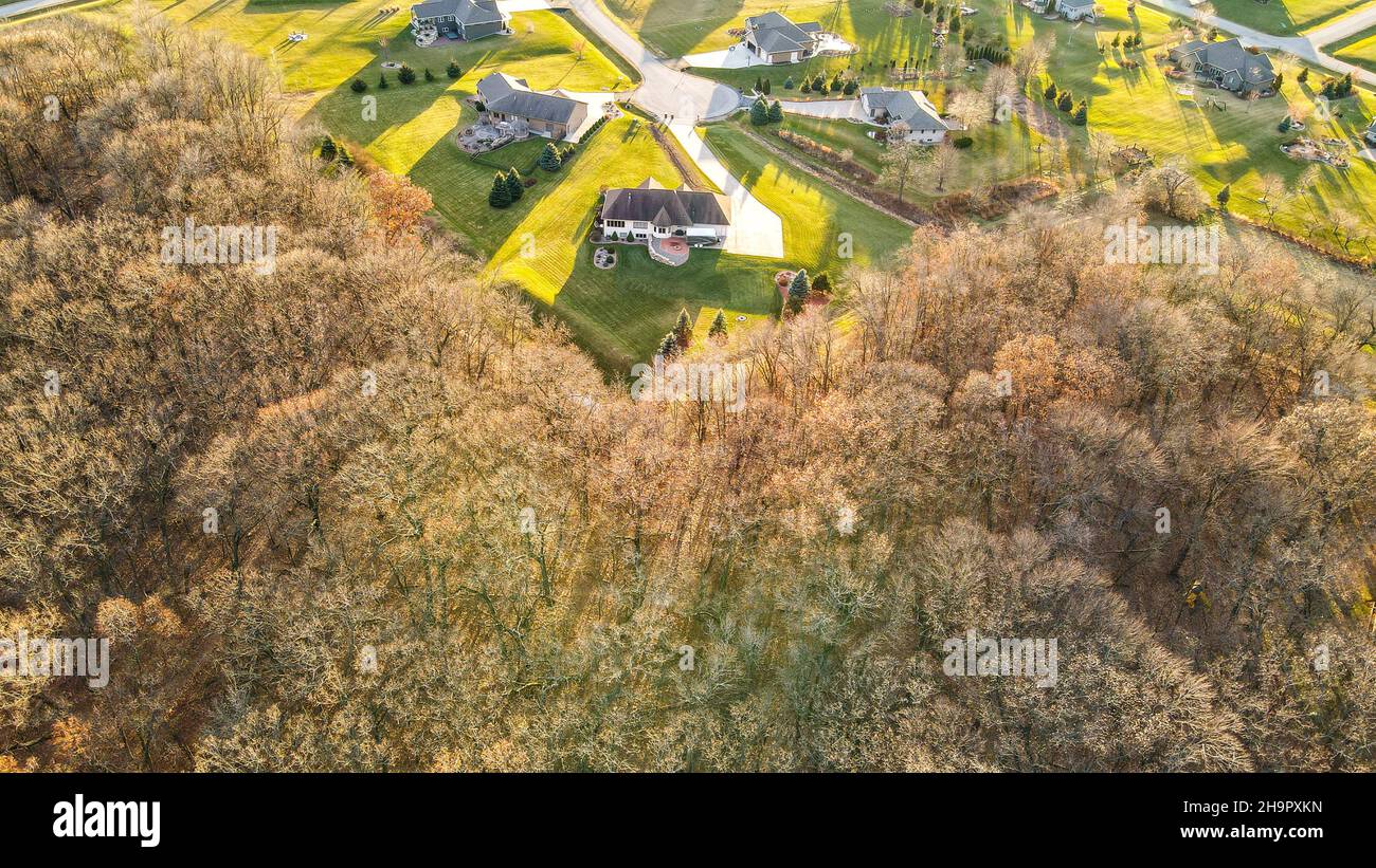 Über den Bäumen erscheinen plötzlich Häuser in perfektem Zustand. Im ländlichen Wisconsin USA Stockfoto