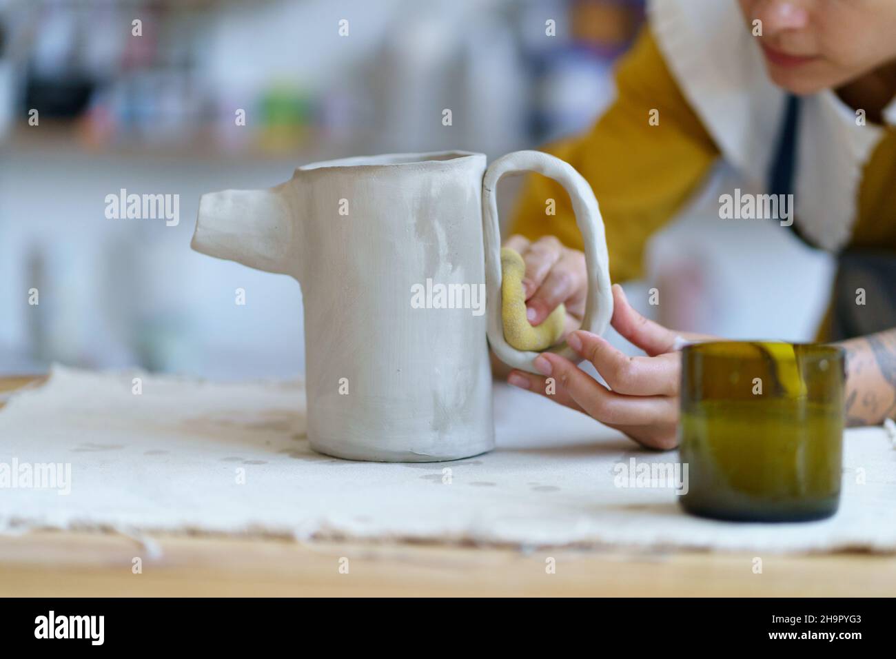 Junge Bildhauerin Mädchen erstellen Keramik Geschirr im Studio. Frau Töpferkünstlerin arbeiten mit nassem Ton Stockfoto