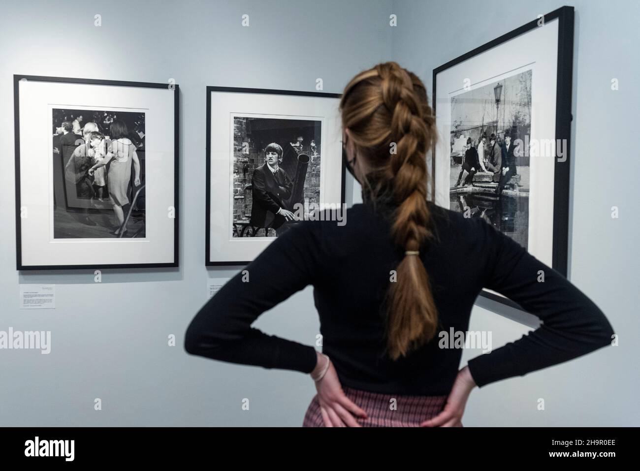 London, Großbritannien. 8. Dezember 2021. Ein Mitarbeiter sieht Fotos in der Vorschau einer Ausstellung von verlorenen Fotos der Beatles von Lord Thynne, Sohn des Marquess of Bath aus dem Jahr 6th. Die Ausstellung mit offenen Bildern der Band im Frühjahr 1964 am Set ihres ersten Films A Hard Day’s Night findet bis zum 16. Januar 2022 in der Shapero Modern Gallery in Mayfair statt. Kredit: Stephen Chung / Alamy Live Nachrichten Stockfoto