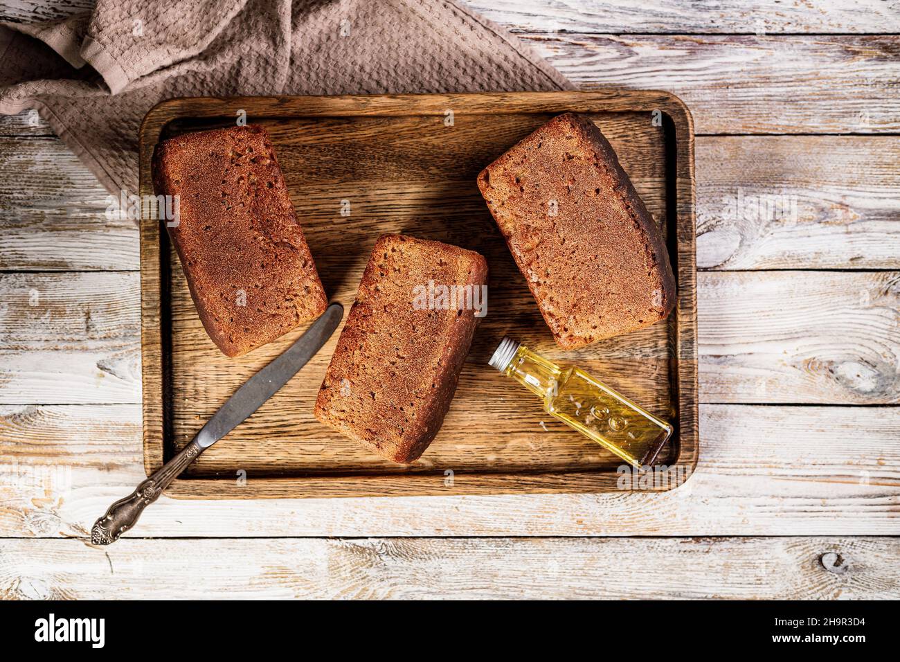 Roggenbrotlaus. Frisches, hausgemachtes Brot aus Vollkorn-Roggenmehl. Köstliches traditionelles Gebäck auf einem Holztablett auf einem rustikalen Hintergrund. Salz Stockfoto