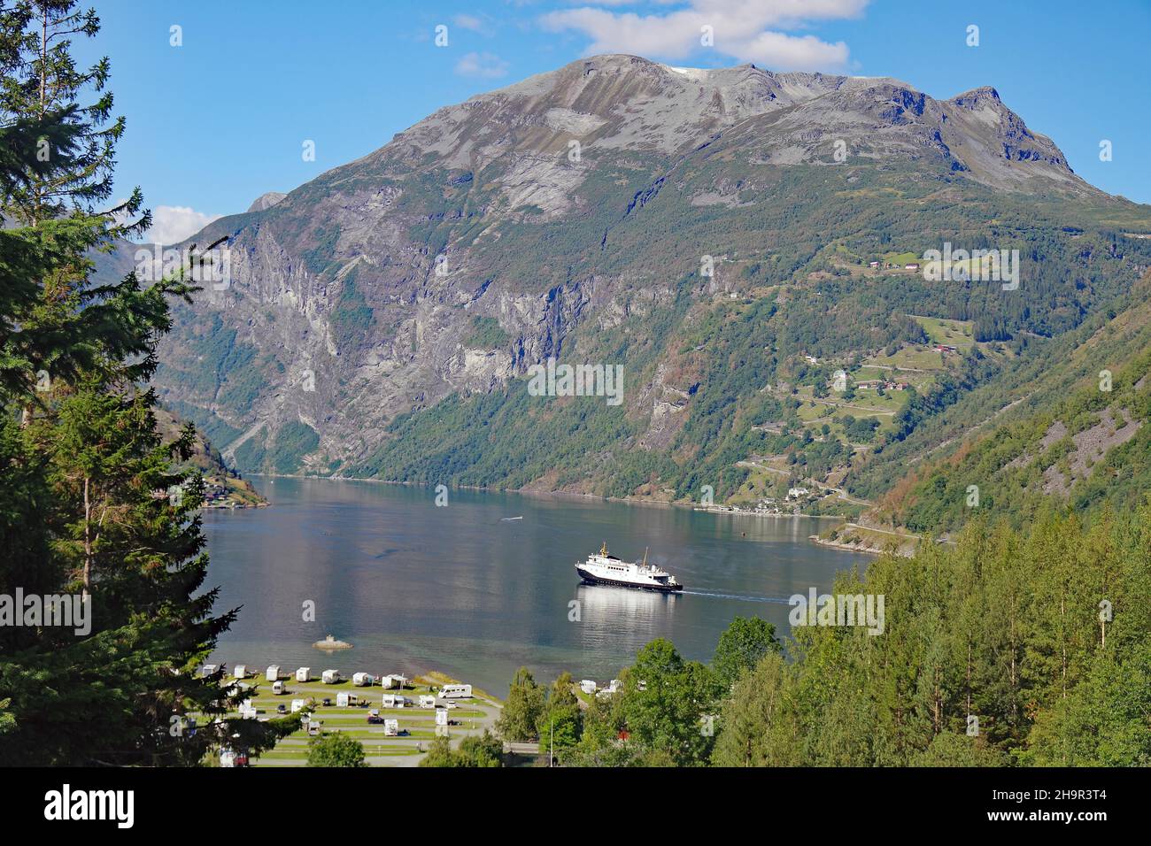 Autofähre, mächtige Berge und kurvenreiche Passstraße, Eagle Road, Geiranger, Norwegen Stockfoto