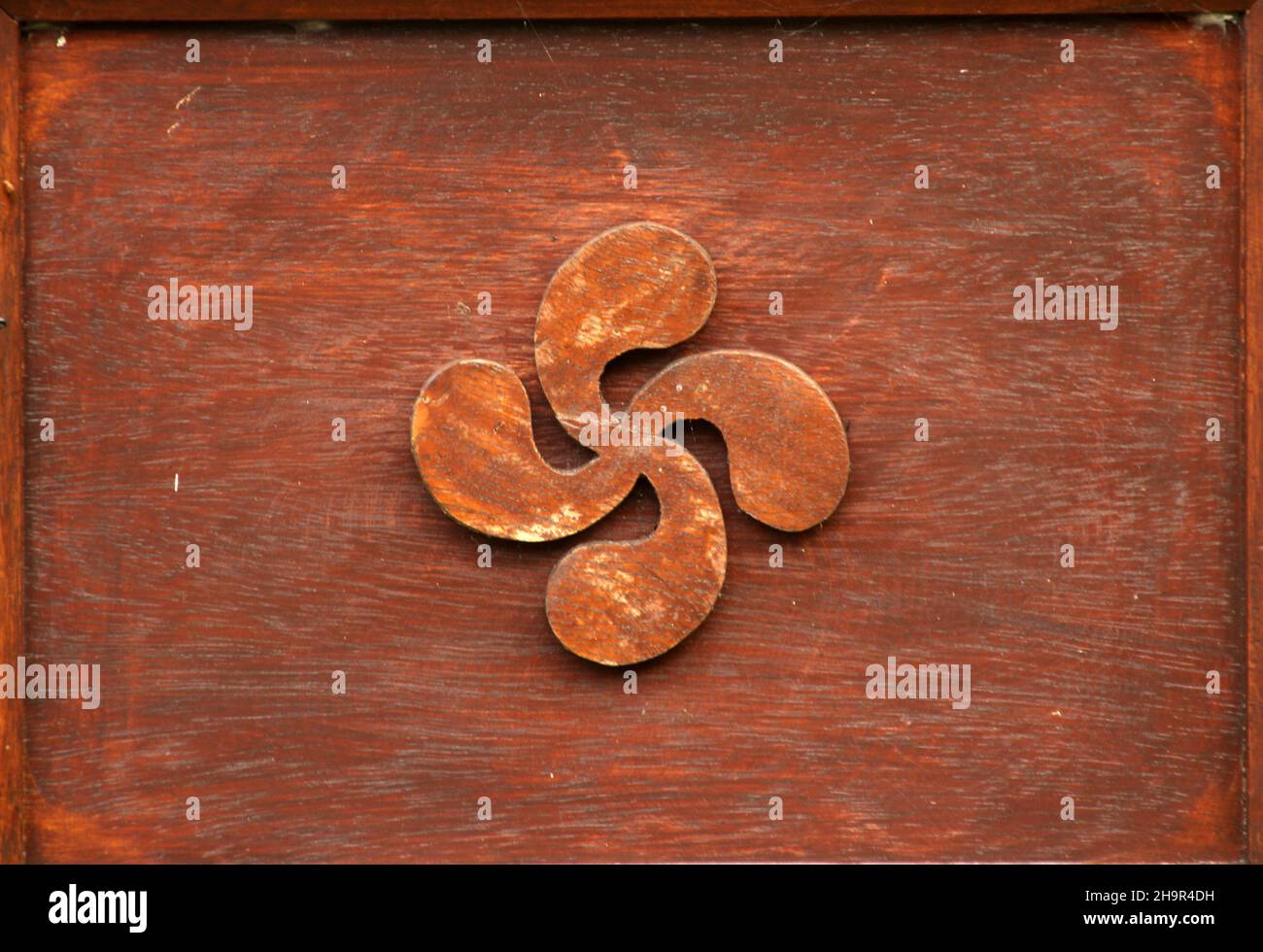 Nahaufnahme von Lauburu vier Köpfe traditionelle Hakenkreuz auf einer rostigen Oberfläche Stockfoto