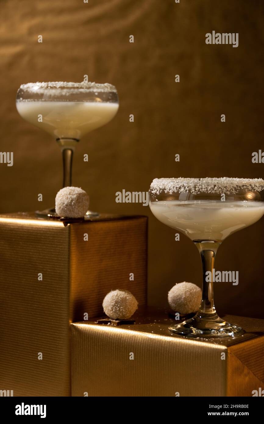 Festliche Getränke. Weiße Coco Cocktails Gläser auf goldenem Hintergrund. Konzept der Feier Stockfoto