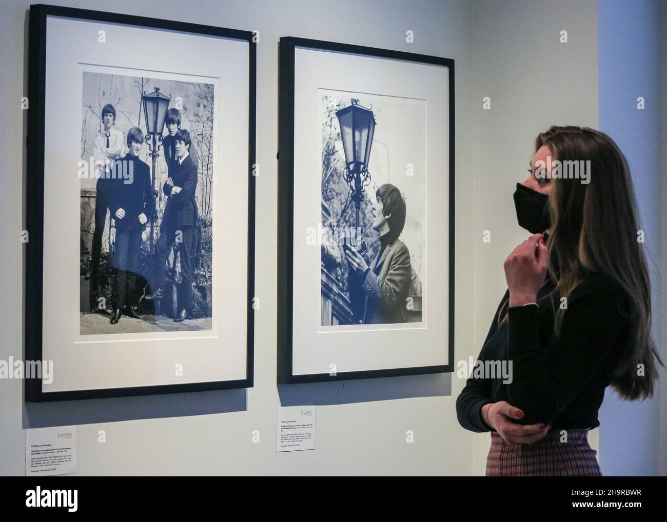 London, Großbritannien. 8th Dez 2021. Ein Mitarbeiter schaut sich die Bilder an. Nach 57 Jahren in Familienpapieren wiederentdeckt und aus Negativen entwickelt, sind verlorene Fotos der Beatles in einer seltenen Ausstellung in der Shapero Modern Gallery zu sehen. Der Fotograf Lord Thynne nahm im Frühjahr 1964 am Set ihres ersten Films A Hard Day's Night offene Aufnahmen der Band auf. Die Negative blieben 57 Jahre lang unentwickelt. Kredit: Imageplotter/Alamy Live Nachrichten Stockfoto