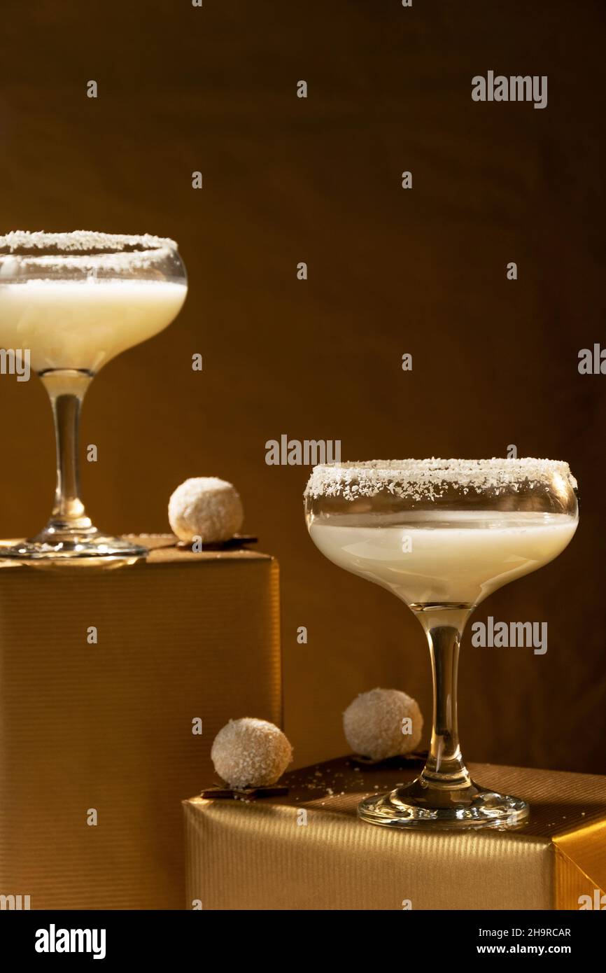 Festliche Getränke. Weiße Coco Cocktails Gläser auf goldenem Hintergrund. Konzept der Feier Stockfoto