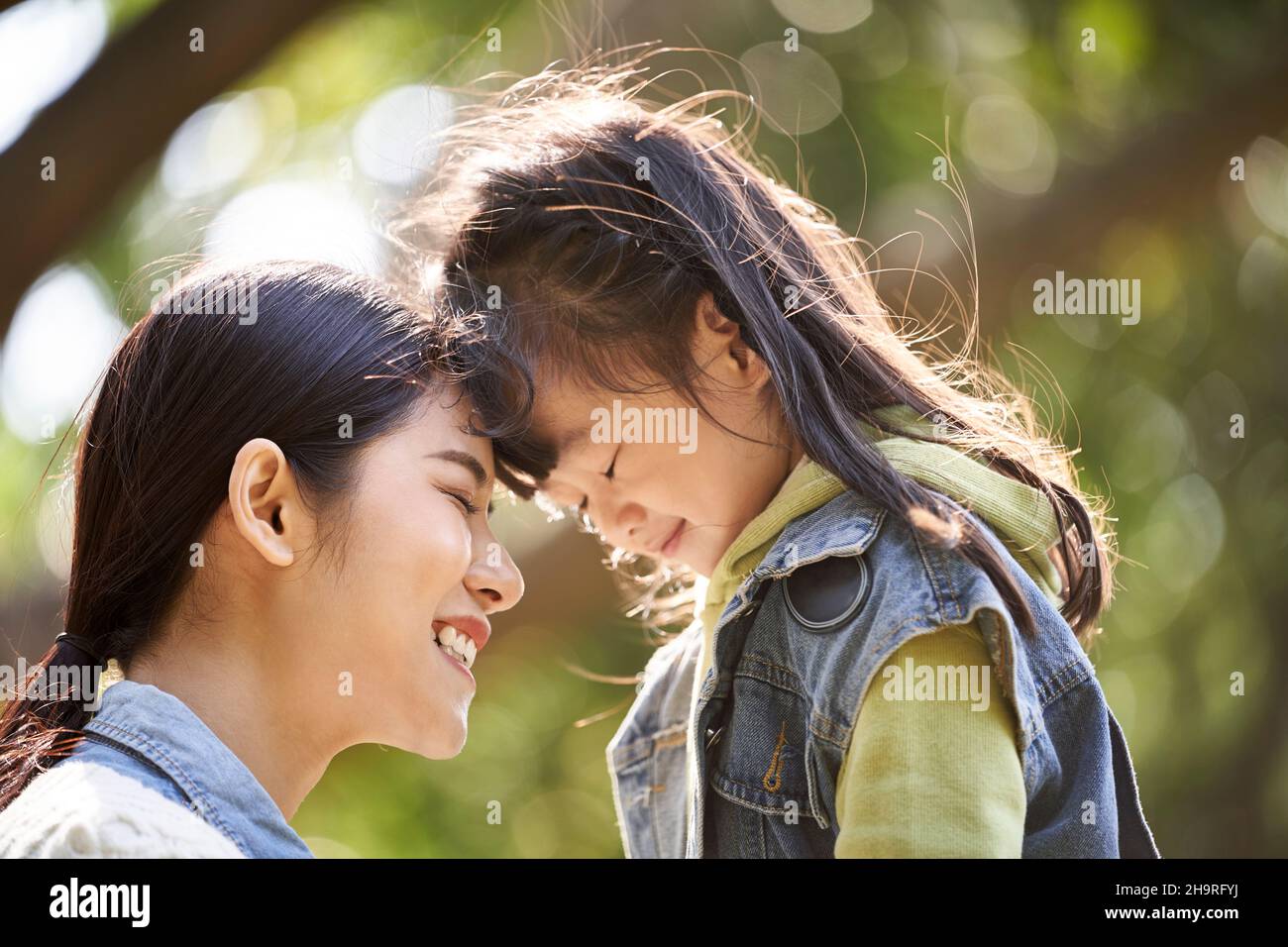 Junge asiatische Mutter und Tochter genießen eine gute Zeit im Stadtpark Stockfoto