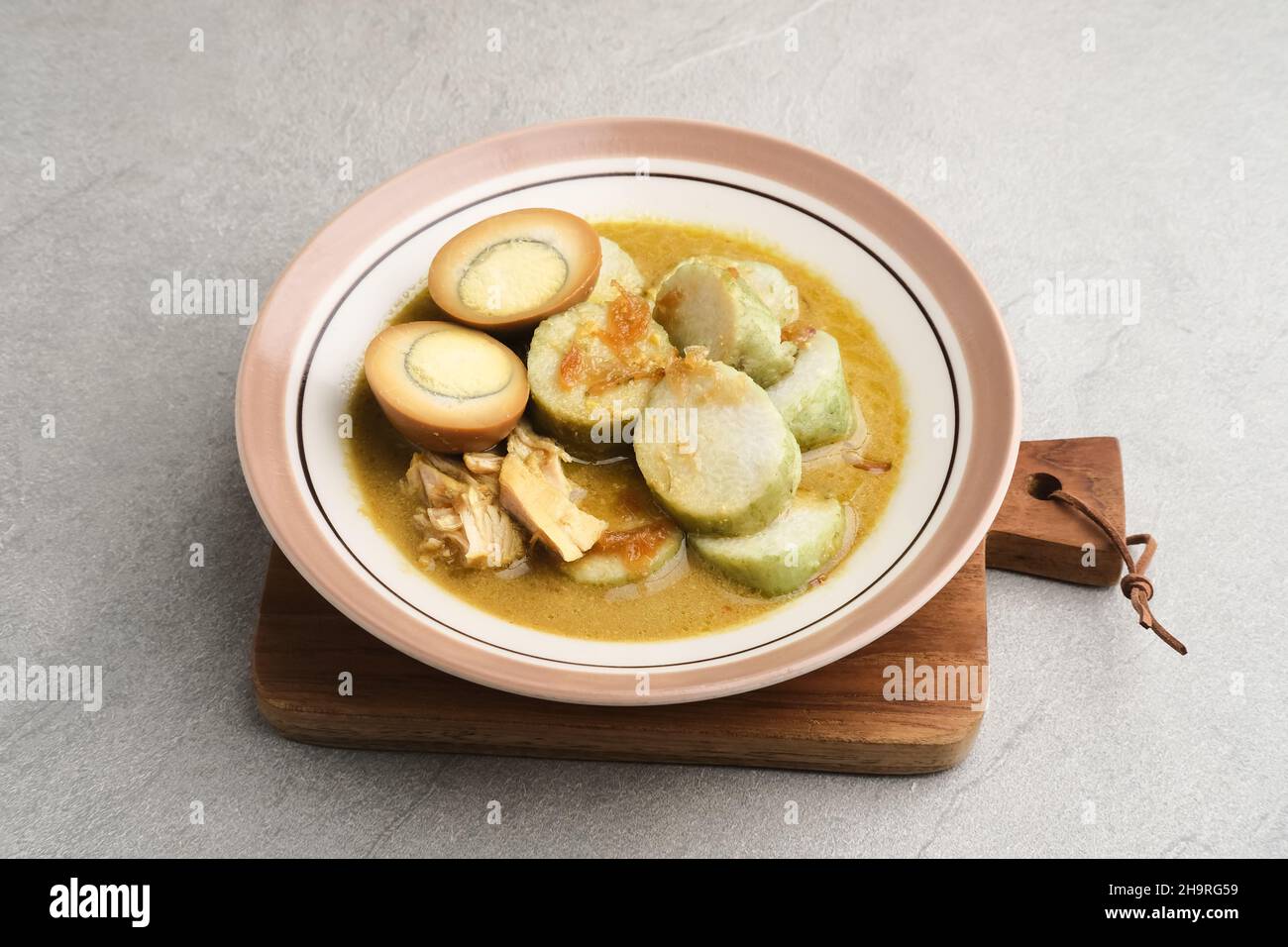 Lontong Opor, traditionelles indonesisches Frühstück oder ein Eid-Menü. Opor aus Huhn mit Kokosmilch und Gewürzen gekocht. Stockfoto