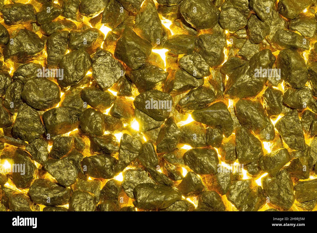 Goldene Nuggets als Hintergrund mit goldenem Licht von unten. Stockfoto