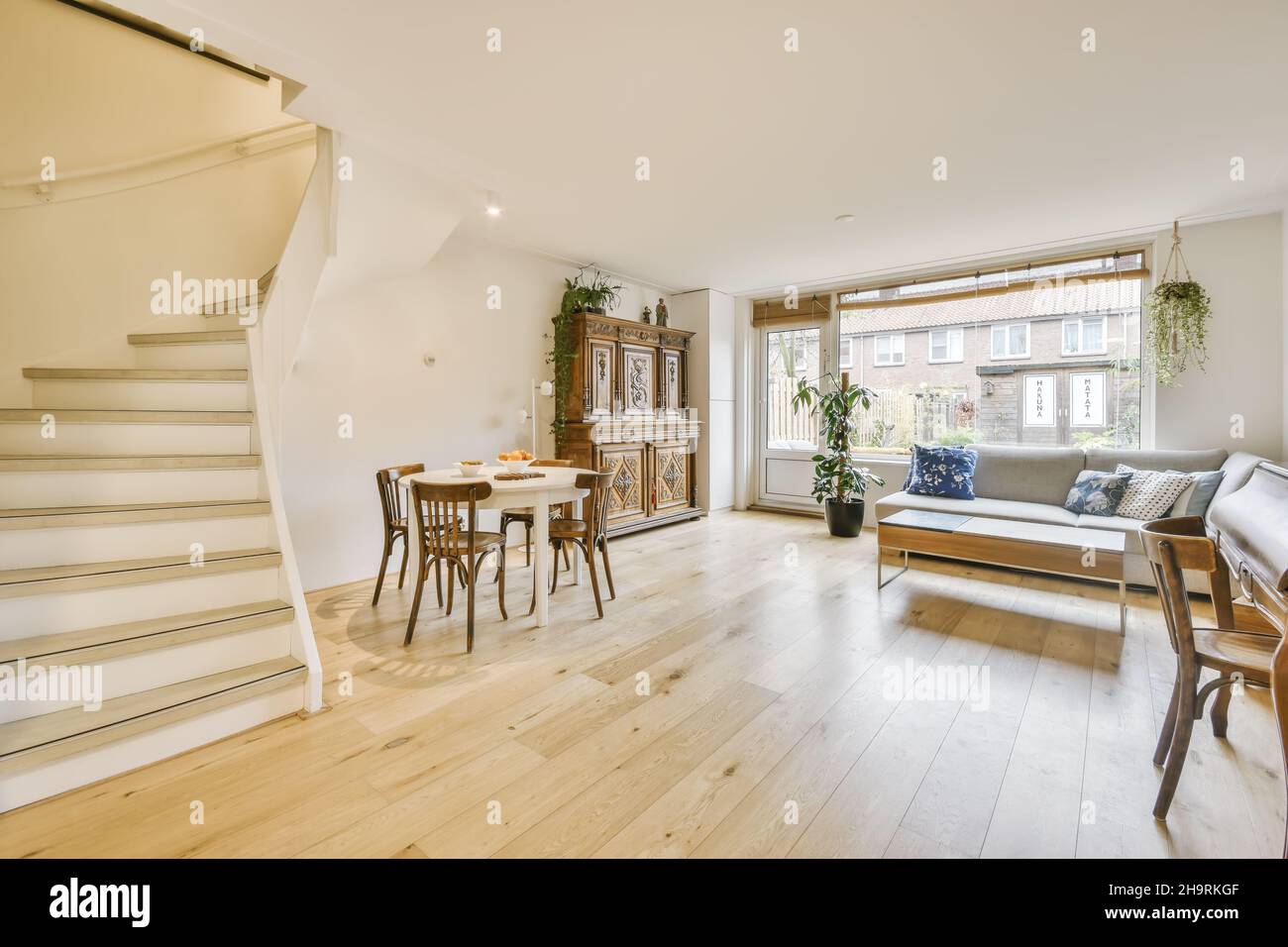 Gemütliches großes Zimmer mit Wohn- und Essbereich und einer großen soliden Treppe Stockfoto