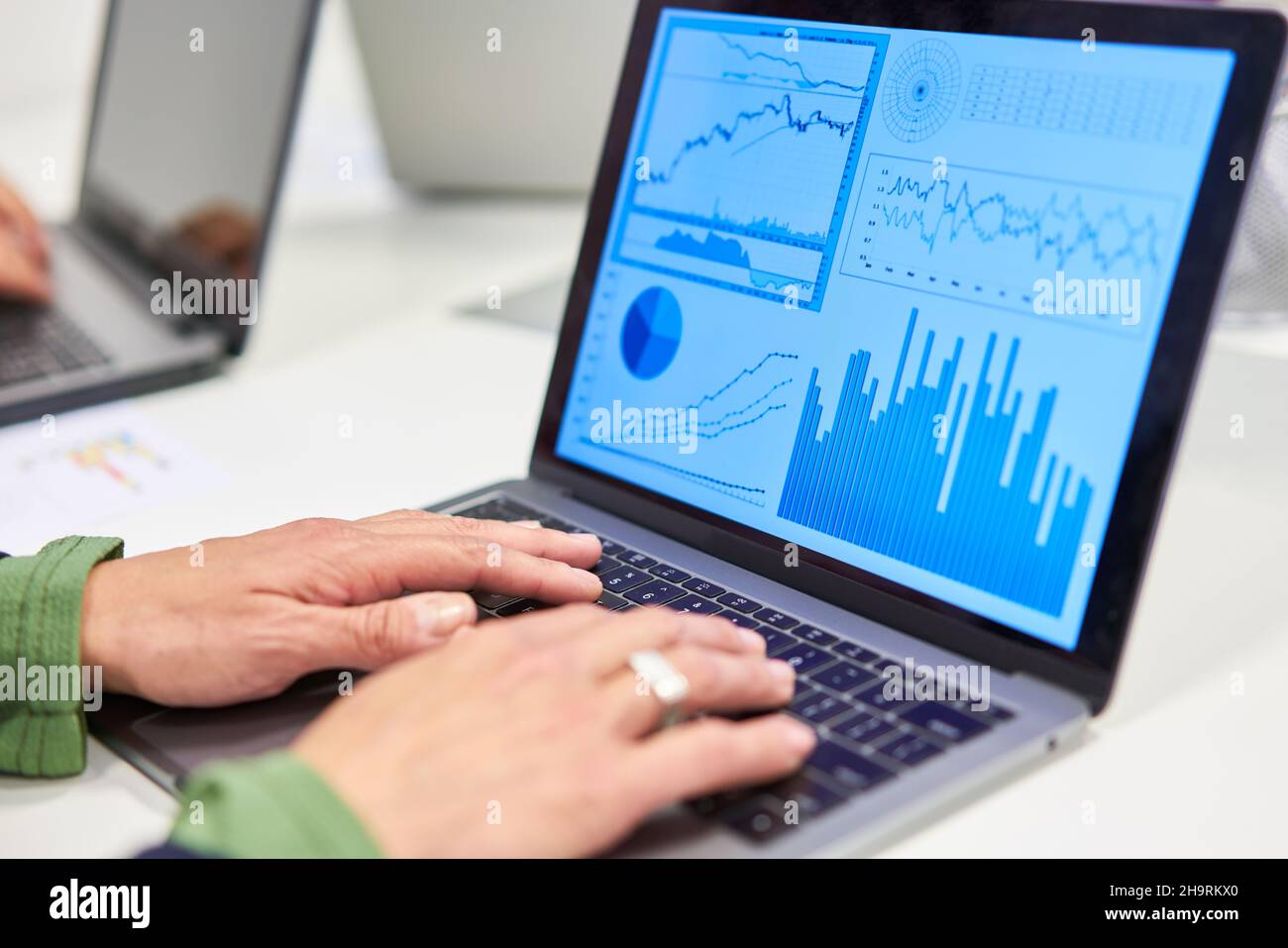 Handschriften auf einem Laptop mit Grafiken und Grafiken in der Finanzanalyse Stockfoto