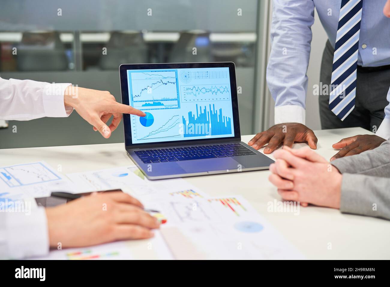 Geschäftsmann zeigt auf Diagramm auf Laptop-Computer während der Finanzanalyse Stockfoto