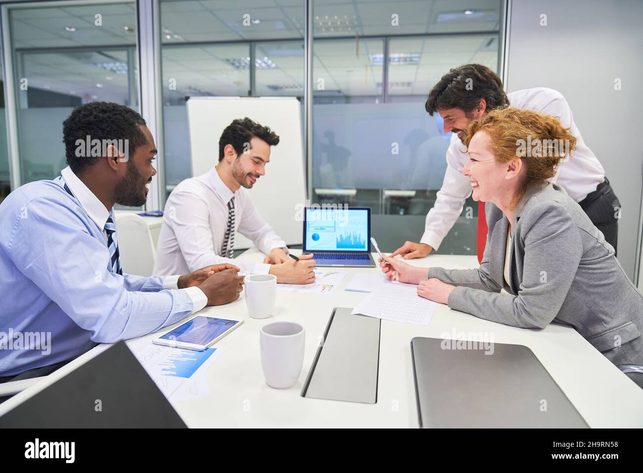 Geschäftsleute treffen sich auf einem Laptop im Konferenzraum Stockfoto