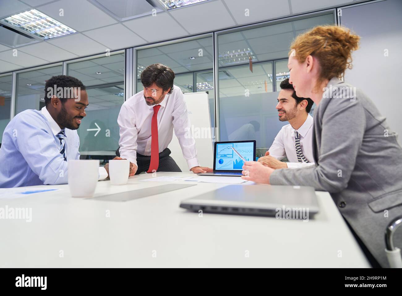 Gruppe von Geschäftsleuten am Konferenztisch mit einem Berater in einem Strategiemeeting Stockfoto