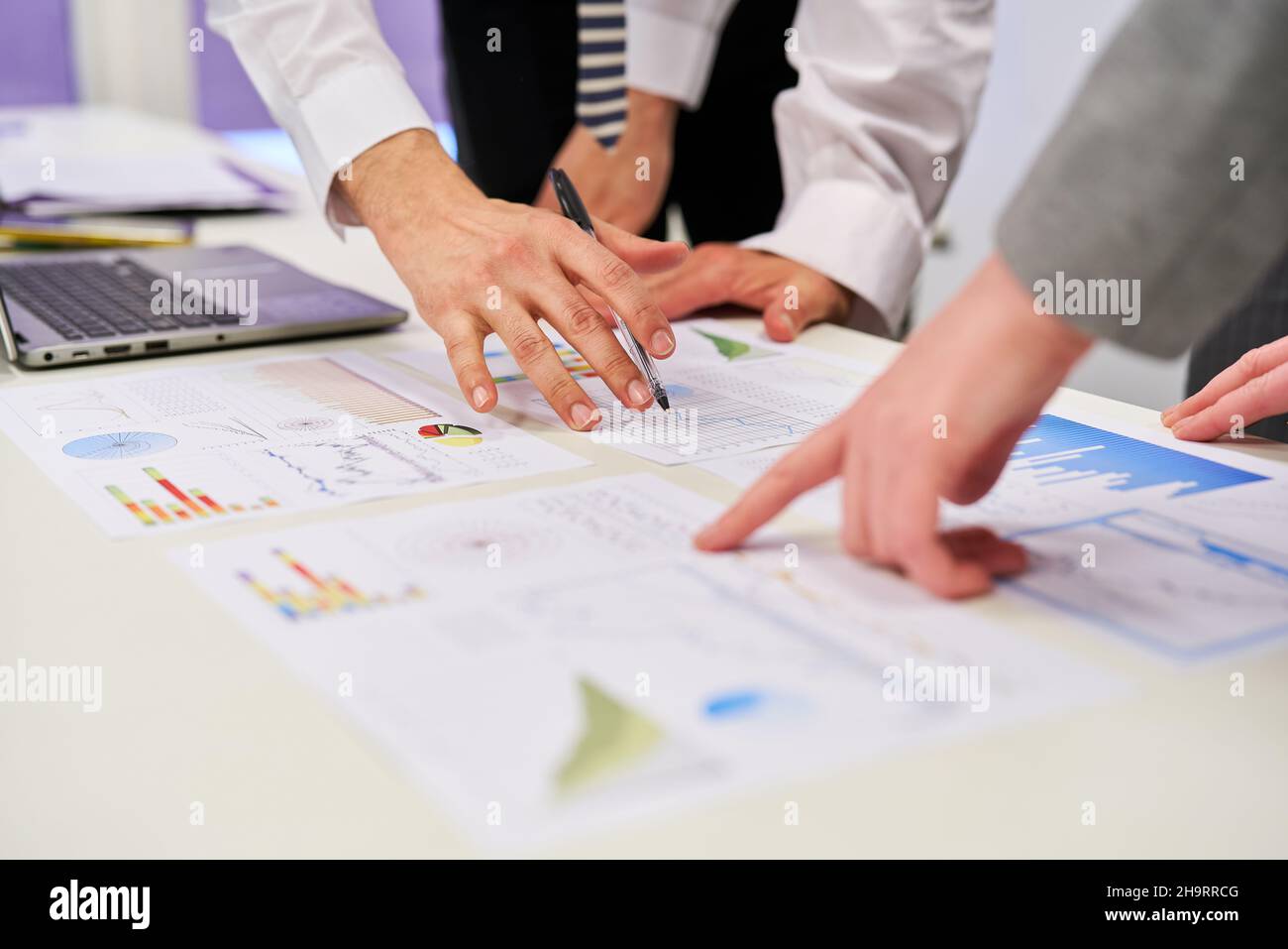 Hände von Geschäftsleuten, die in der Finanzplanung auf Diagramme und Grafiken zeigen Stockfoto