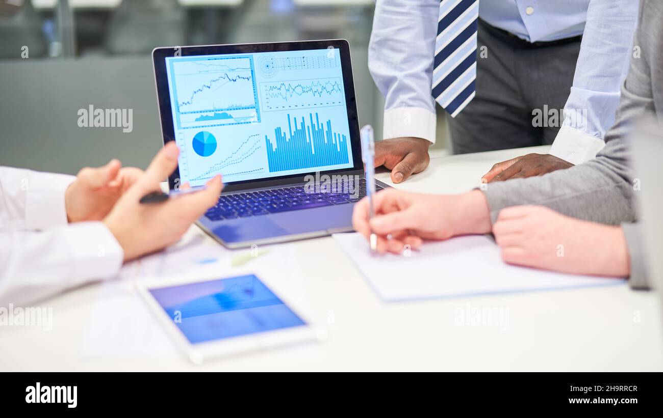 Geschäftsleute am Laptop mit Daten in der Finanzanalyse und Risikoanalyse Stockfoto