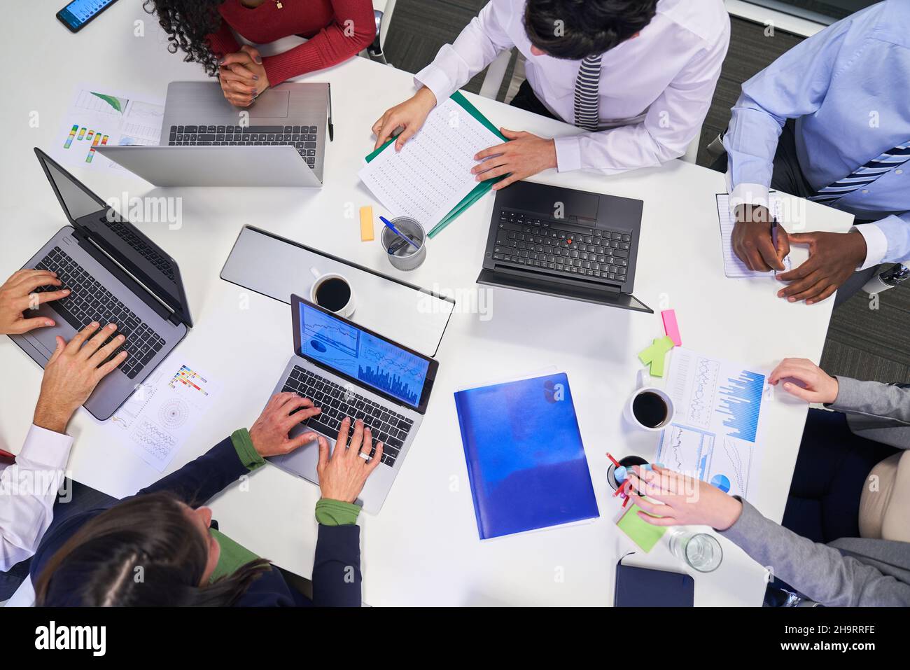 Geschäftsleute, die während der Finanzplanung am Konferenztisch mit einem Computer zusammentreffen Stockfoto