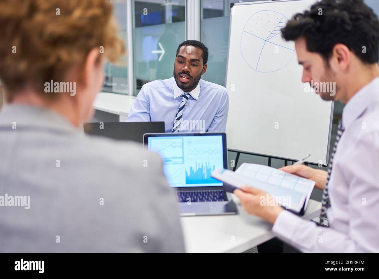 Drei Geschäftsleute, internationales Startup-Team, das die Finanzplanung am pc im Büro voranthat Stockfoto