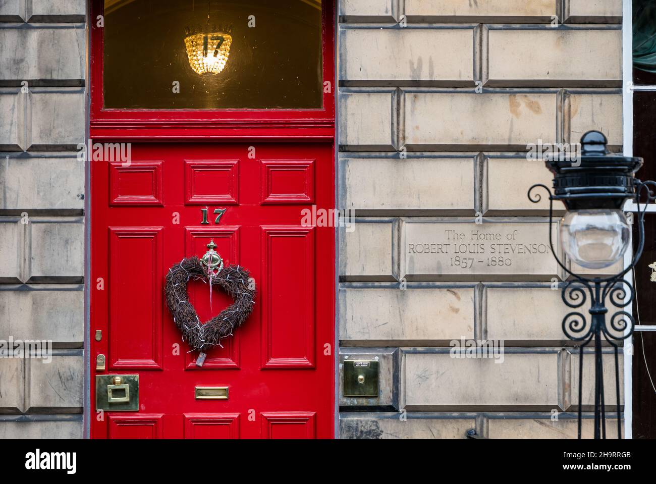 Georgianisches Stadthaus, in dem Robert Louis Stevenson mit einem Weihnachtskranz und einem altmodischen Lampenpfosten lebte, Heriot Row, Edinburgh New Town, Schottland, Großbritannien Stockfoto