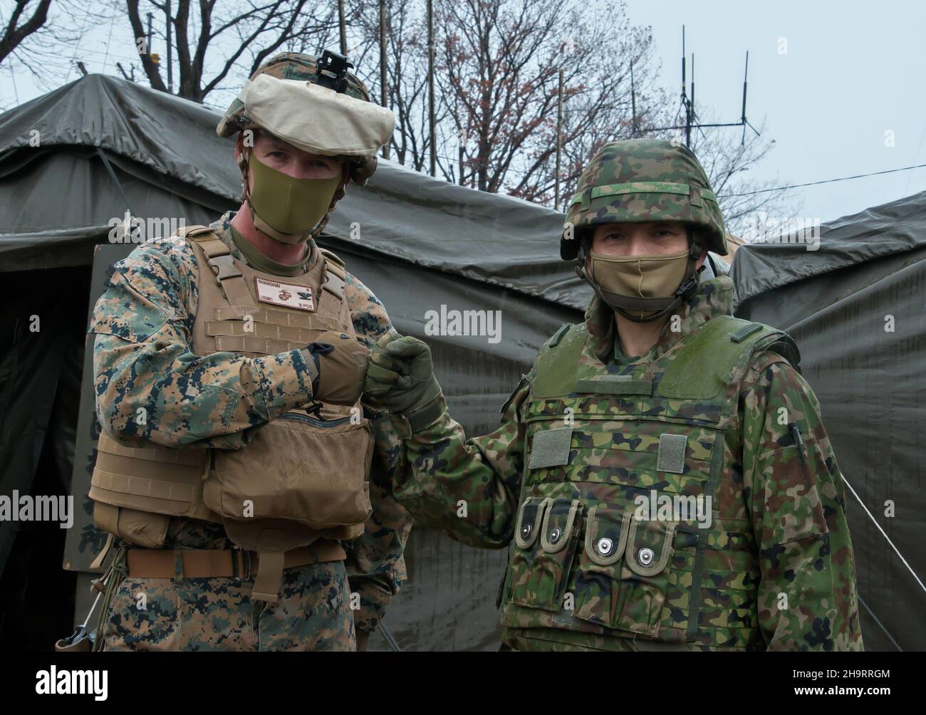 Der Kommandant des Marine Regiments 4th, Oberst Matthew W. Tracy (L), schlägt am 8. Dezember 2021 mit dem Chef des JGSDF Infanterie-Regiments 5th, Oberst Yoshio Furihata, während der gemeinsamen Militärübung „Resolute Dragon 21“ von JGSDF und der US Marine auf dem Ojojihara-Testgelände in der Präfektur Miyagi, Japan, Fäuste. Foto von Keizo Mori/UPI Stockfoto