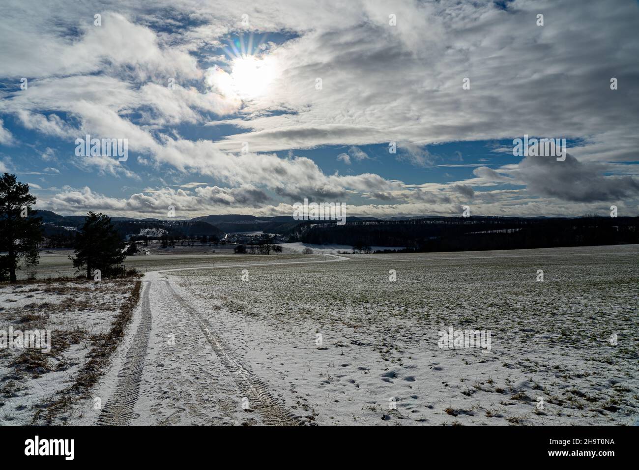 Blick auf ein schneebedecktes Feld im Winter bei strahlendem Sonnenschein mit blauem Himmel Stockfoto