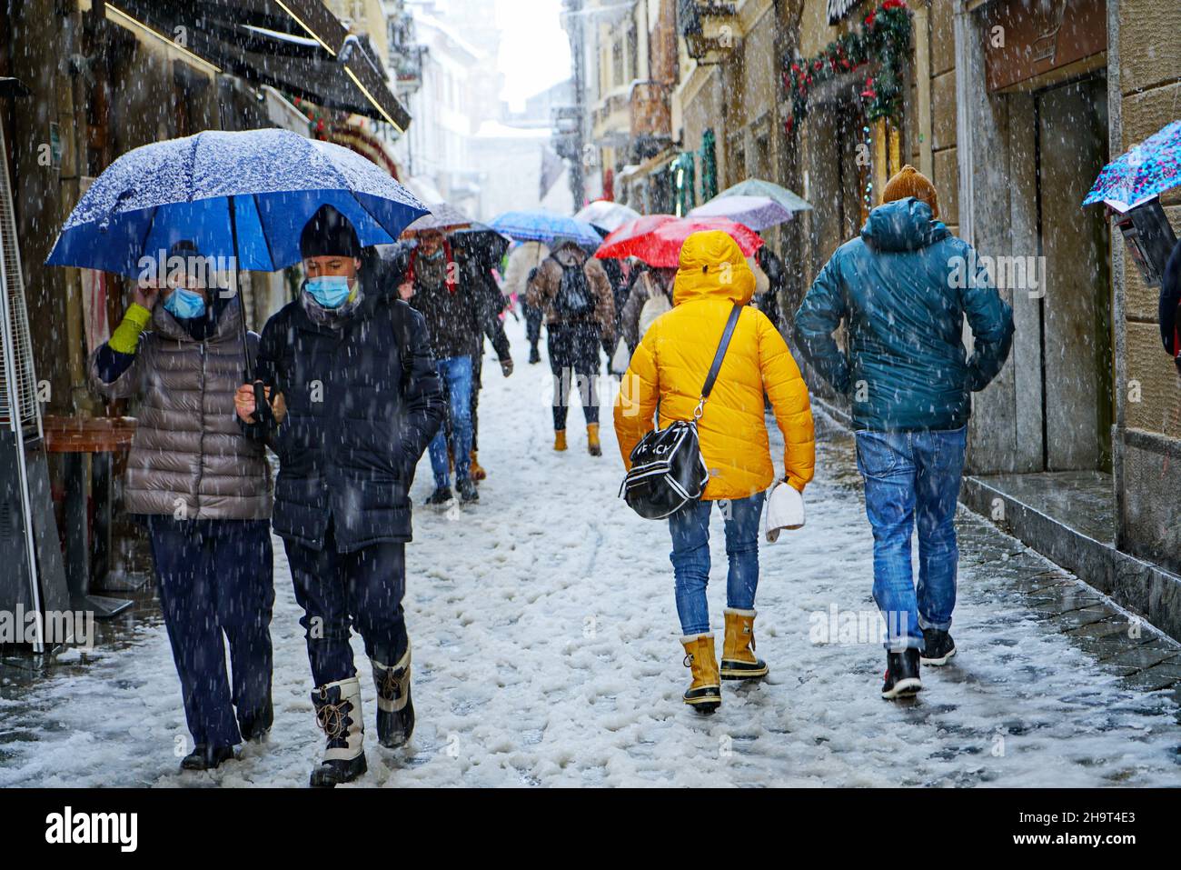 Die Stadt wurde von einem Schneesturm, Kälte, Klimawandel bedeckt, Menschen gehen unter dem Schneesturm. Aosta, Italien – Dezember 2021 Stockfoto